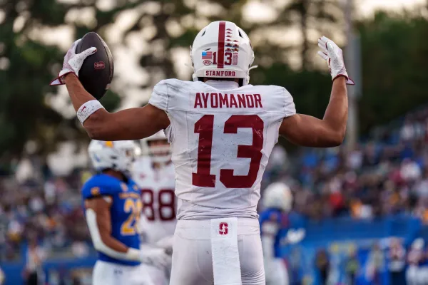 Football player holds ball on the field.